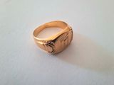 a close up of a gold ring on a white surface