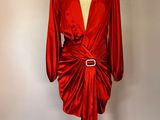 robe en satin rouge posée sur un présentoir à mannequin, avec une ceinture