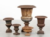 four vases sitting on top of each other on a cement floor