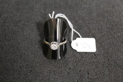a silver ring with a diamond on it sitting on a black surface