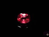 un gros plan sur un diamant rouge dans l'obscurité