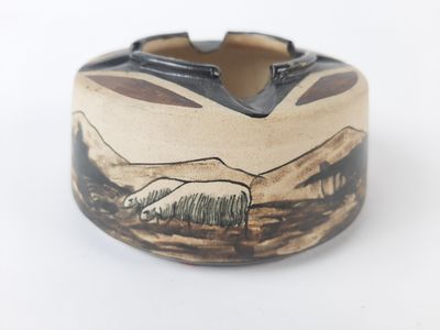 a brown and black ashtray with a picture of a mountain