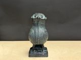une figurine de chouette posée sur une table en bois