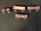 four toy train cars are lined up on a black surface