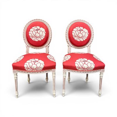 une paire de chaises rouges et blanches ornées de fleurs blanches