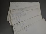 a stack of papers with writing on them on a table