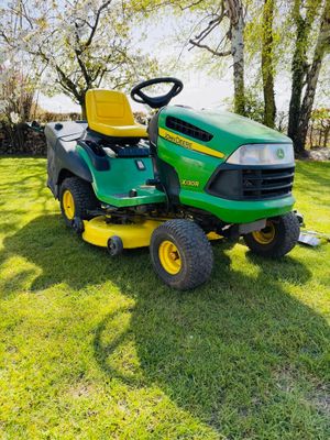a green lawn mower sitting on top of a lush green field