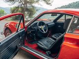 a red car with its door open sitting on the side of the road
