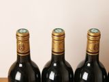 four bottles of wine are lined up on a wooden table