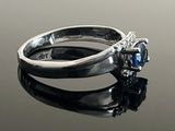a ring with a blue stone on a black surface