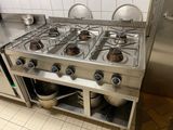 stainless steel stove top with pots and pans on it in a commercial kitchen