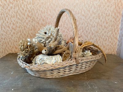 a teddy bear sitting in a wicker basket on a table
