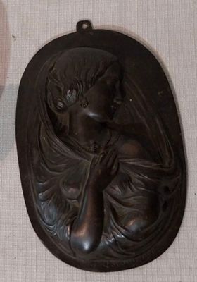 une photo représentant une statue d'une femme tenant une bougie