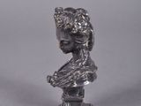 an image of a silver statue of a woman with a flower in her hair