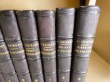 Plusieurs livres sont alignés sur une étagère dans une bibliothèque