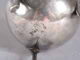 a silver tea pot with a handle on a table