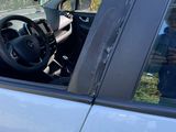 a dog sitting in the driver ' s seat of a car