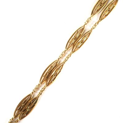 gros plan d'un bracelet en or sur fond blanc