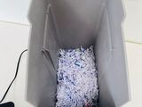 a box of shredded paper and a laptop on the table