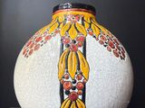 un vase blanc orné d'un motif jaune et rouge