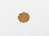 a close up of a gold coin on a white surface