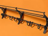 a close up of a metal rack with hooks on an orange background