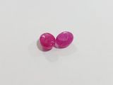 a pair of pink sapphires on a white surface