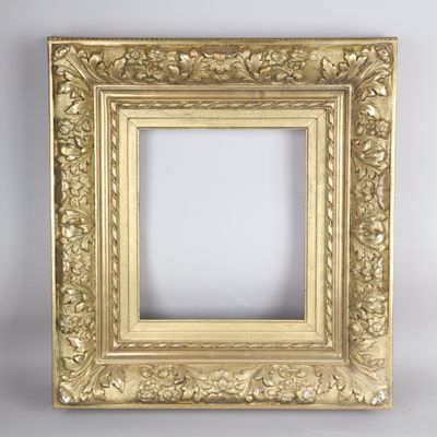 a gold picture frame with leaves and scrolls on a white background