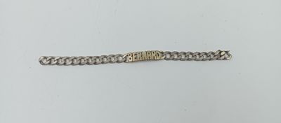 gros plan d'un bracelet en chaîne en argent sur une surface blanche