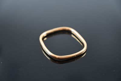 a close up of a gold ring sitting on top of a black surface