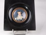 a small black plate with a picture of a woman in a white dress