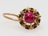 a close up of a pink and black diamond ring on a white surface