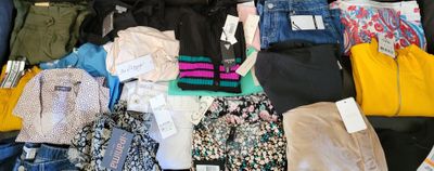 a suitcase full of clothes and clothes that are on the floor