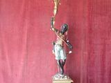 statue of a boy holding a candelabra on a pedestal