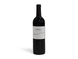 la bouteille de vin rouge est posée sur une surface blanche