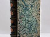an old book sitting on top of a white surface