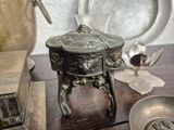 a silver object on a table next to a silver bowl