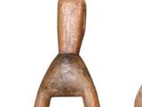 two wooden figurines sitting next to each other on a white surface