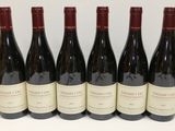 six bouteilles de vin sont alignées sur une table