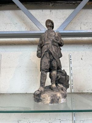 une statue représentant un homme tenant un chien sur une étagère en verre