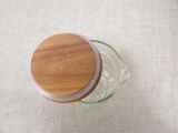 a glass jar with a wooden lid sitting on a table