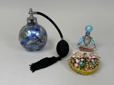 une petite bouteille en verre avec une poignée noire, à côté d'une petite bouteille en verre avec une poignée noire, à côté d'une petite bouteille en verre avec une poignée noire