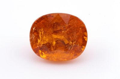un gros plan d'un saphir orange sur une surface blanche