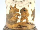 a vase with a painting on it on a stand