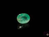 a close up of a green emerald on a black surface