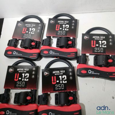 Six casques audio rouges et noirs sont posés sur une table blanche.