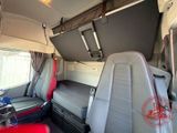 two seats in the back of a bus with a bed