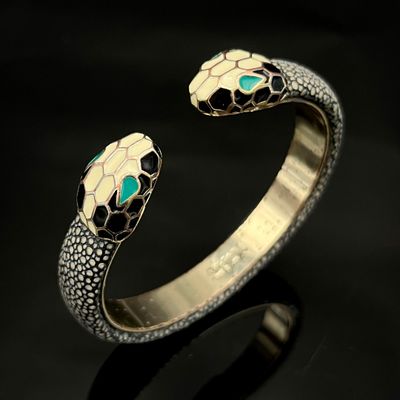un gros plan de la tête d'un serpent sur un bracelet en or