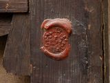 a wax seal on a piece of wood that is on a table