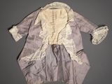 un vieux manteau violet orné de dentelle blanche au col et aux poignets